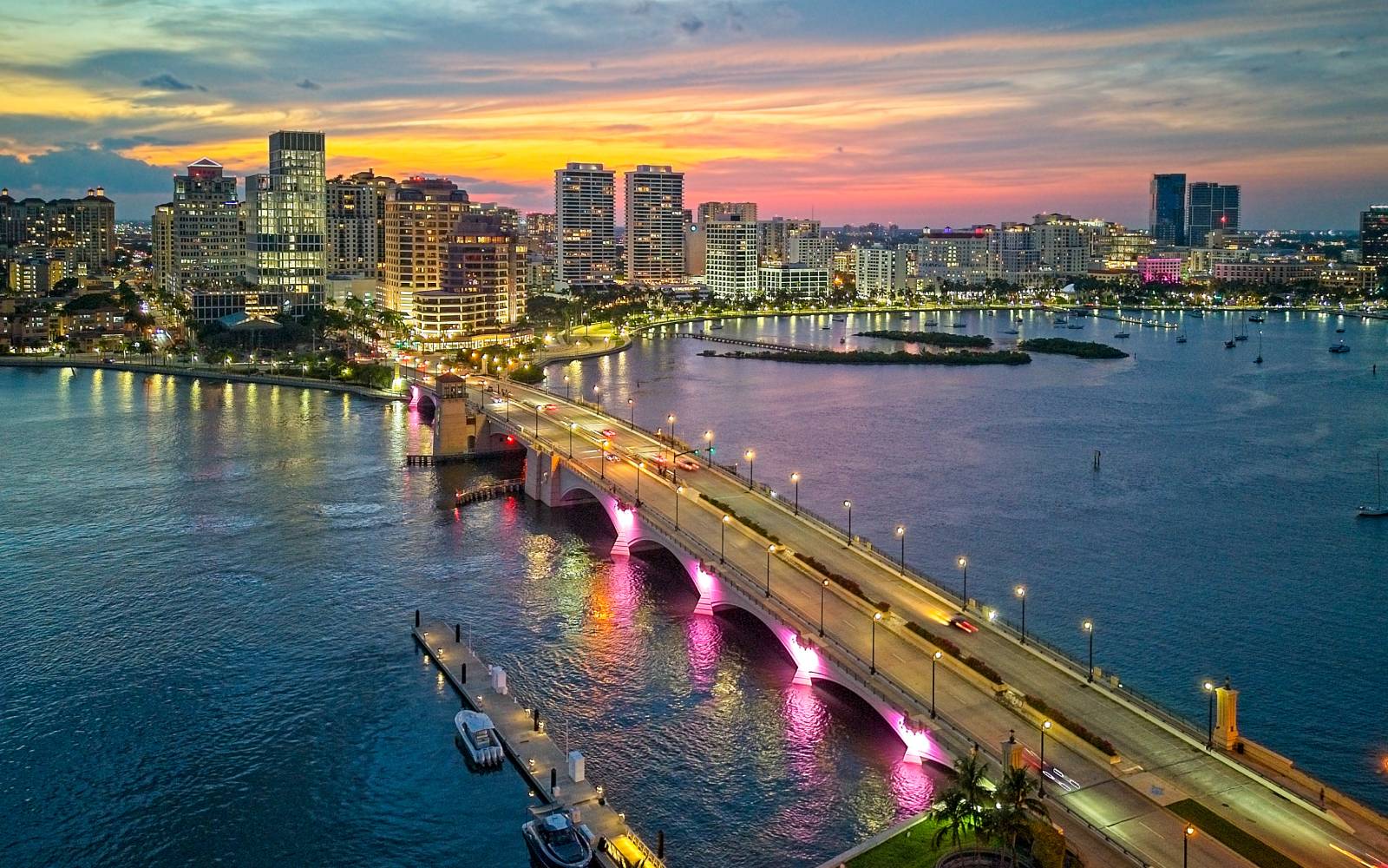 Coastal city skyline and bridge at sunset